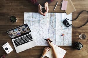 A travel planning desk with a map, camera and notebook laid out for a trip