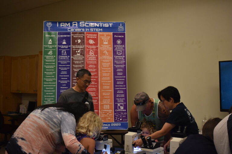 Children taking part in hands-on interactive science activities at a museum exhibit table